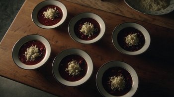 Movie still from “Curse of Chucky” (2013), directed by Don Mancini – A wooden table topped with six bowls of soup; Extreme Close Up shot, High angle