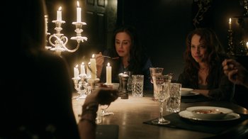 Movie still from “Curse of Chucky” (2013), directed by Don Mancini – A group of people sitting around a table with candles; Medium shot, Over the shoulder angle
