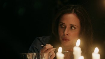 Movie still from “Curse of Chucky” (2013), directed by Don Mancini – A woman sitting in front of a lit candle; Close Up shot, Over the shoulder angle