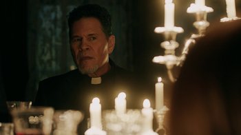 Movie still from “Curse of Chucky” (2013), directed by Don Mancini – A priest looking at himself in a mirror; Close Up shot, Over the shoulder angle