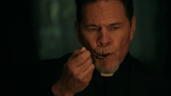 Movie still from “Curse of Chucky” (2013), directed by Don Mancini – A man in a black shirt is eating something; Close Up shot, High angle