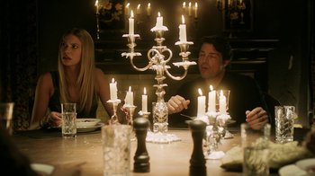 Movie still from “Curse of Chucky” (2013), directed by Don Mancini – A man and a woman sitting at a dinner table with lit candles; Medium shot, Over the shoulder angle