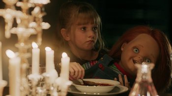 Movie still from “Curse of Chucky” (2013), directed by Don Mancini – A little girl sitting at a table with a plate of food; Medium shot, Over the shoulder angle