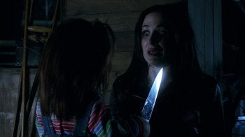 Movie still from “Curse of Chucky” (2013), directed by Don Mancini – A woman holding a knife near a child; Close Up shot, Over the shoulder angle