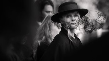 Movie still from “Curse of Chucky” (2013), directed by Don Mancini – A woman wearing a black hat and a black coat; Close Up shot, Over the shoulder angle
