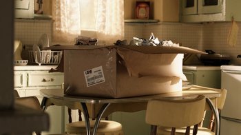 Movie still from “Curse of Chucky” (2013), directed by Don Mancini – A box sitting on top of a table in a kitchen; Medium shot, High angle