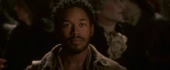 Movie still from “Cyrano” (2021), directed by Joe Wright – A person wearing a jacket; Close Up shot, Over the shoulder angle