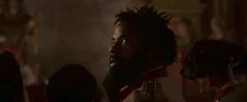 Movie still from “Cyrano” (2021), directed by Joe Wright – A person with a beard looking to his left; Close Up shot, Low angle