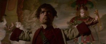 Movie still from “Cyrano” (2021), directed by Joe Wright – A person wearing a red shirt; Medium shot, Low angle