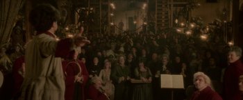 Movie still from “Cyrano” (2021), directed by Joe Wright – A group of people sitting in front of a crowd; Extreme Wide shot, High angle