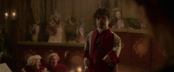 Movie still from “Cyrano” (2021), directed by Joe Wright – A man holding a sword in front of other people; Medium shot, Low angle