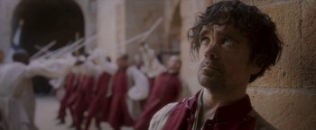 Movie still from “Cyrano” (2021), directed by Joe Wright – A man that is standing in front of a group of people; Medium shot, Low angle