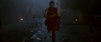 Movie still from “Cyrano” (2021), directed by Joe Wright – A man walking in the middle of a street; Wide shot, High angle