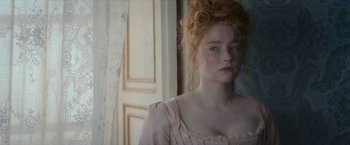 Movie still from “Cyrano” (2021), directed by Joe Wright – A young woman with red curly hair and a pink dress; Close Up shot, Over the shoulder angle