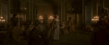 Movie still from “Cyrano” (2021), directed by Joe Wright – A woman in an old - fashioned dress stands in front of a group of people; Wide shot, Low angle