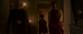 Movie still from “Cyrano” (2021), directed by Joe Wright – A man and a woman standing in a room with candles; Wide shot, Low angle