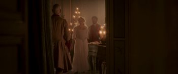 Movie still from “Cyrano” (2021), directed by Joe Wright – A woman in a white dress standing in front of two men; Wide shot, Over the shoulder angle