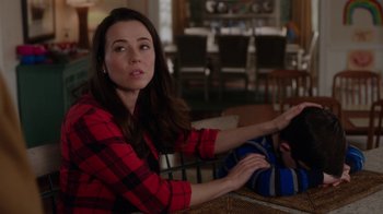 Movie still from “Daddy's Home” (2015), directed by Sean Anders – A woman sitting at a table with her hand raised; Medium shot, Over the shoulder angle