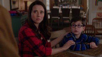 Movie still from “Daddy's Home” (2015), directed by Sean Anders – A woman sitting next to a young boy in front of a wooden table; Close Up shot, Over the shoulder angle