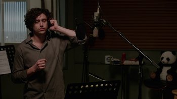 Movie still from “Daddy's Home” (2015), directed by Sean Anders – A man standing in front of a microphone in a recording studio; Medium shot, Low angle