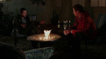 Movie still from “Daddy's Home” (2015), directed by Sean Anders – Two men sitting around a fire pit with bottles of alcohol; Wide shot, High angle