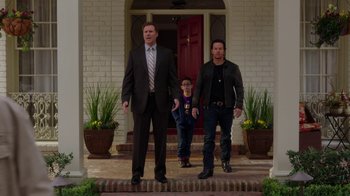 Movie still from “Daddy's Home” (2015), directed by Sean Anders – Two men and a boy standing in front of a house; Wide shot, Over the shoulder angle