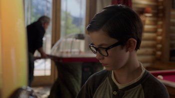 Movie still from “Daddy's Home 2” (2017), directed by Sean Anders – A young boy wearing glasses looking down at a table; Close Up shot, Over the shoulder angle