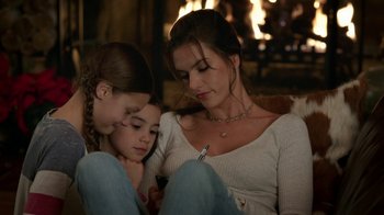 Movie still from “Daddy's Home 2” (2017), directed by Sean Anders – A woman and two young girls sitting in front of a fireplace; Close Up shot, High angle