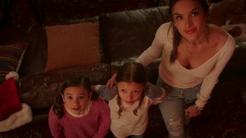 Movie still from “Daddy's Home 2” (2017), directed by Sean Anders – A woman and two young girls sitting on a couch; Medium shot, High angle