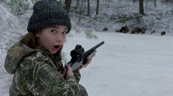 Movie still from “Daddy's Home 2” (2017), directed by Sean Anders – A little girl holding a rifle in the snow; Close Up shot, High angle