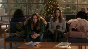 Movie still from “Daddy's Home 2” (2017), directed by Sean Anders – Two women are sitting on a couch and one of them is holding a coffee cup; Wide shot, Over the shoulder angle