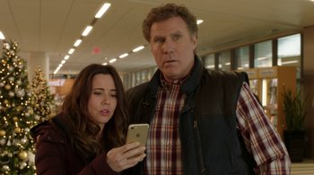 Movie still from “Daddy's Home 2” (2017), directed by Sean Anders – A man and a woman looking at a cell phone; Medium shot, Over the shoulder angle