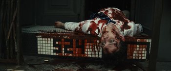 Movie still from “Daniel Isn't Real” (2019), directed by Adam Egypt Mortimer – A woman laying on the ground covered in blood; Medium shot, High angle