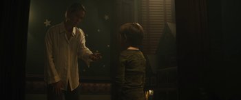 Movie still from “Daniel Isn't Real” (2019), directed by Adam Egypt Mortimer – A man and a boy are standing in a dark room; Medium shot, Low angle