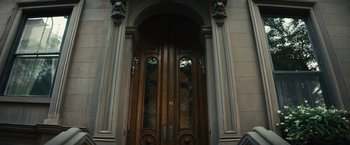 Movie still from “Daniel Isn't Real” (2019), directed by Adam Egypt Mortimer – A large wooden double door with a stained glass window; Extreme Wide shot, Low angle