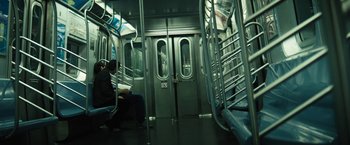 Movie still from “Daniel Isn't Real” (2019), directed by Adam Egypt Mortimer – A man sitting on a subway train next to a door way; Wide shot, High angle