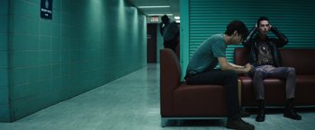 Movie still from “Daniel Isn't Real” (2019), directed by Adam Egypt Mortimer – A person sitting on a couch in a room; Medium shot, High angle