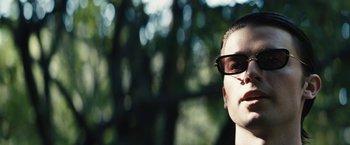 Movie still from “Daniel Isn't Real” (2019), directed by Adam Egypt Mortimer – A man with glasses is looking into the distance; Close Up shot, Low angle