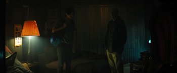 Movie still from “Daniel Isn't Real” (2019), directed by Adam Egypt Mortimer – Two people standing in a dark room next to each other; Medium shot, Over the shoulder angle