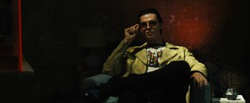 Movie still from “Daniel Isn't Real” (2019), directed by Adam Egypt Mortimer – A man sitting in a chair wearing a yellow jacket; Medium shot, Low angle