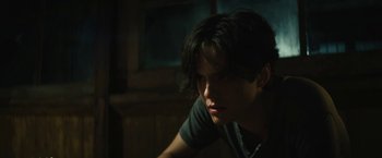 Movie still from “Daniel Isn't Real” (2019), directed by Adam Egypt Mortimer – A person sitting in a dark room looking down at the floor; Close Up shot, Low angle