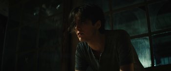 Movie still from “Daniel Isn't Real” (2019), directed by Adam Egypt Mortimer – A young man is sitting in a dark room; Close Up shot, Low angle