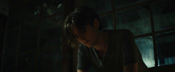 Movie still from “Daniel Isn't Real” (2019), directed by Adam Egypt Mortimer – A young man in a dark room looking down at the floor; Close Up shot, Low angle