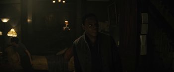 Movie still from “Daniel Isn't Real” (2019), directed by Adam Egypt Mortimer – A man standing in the dark in a room; Medium shot, Over the shoulder angle