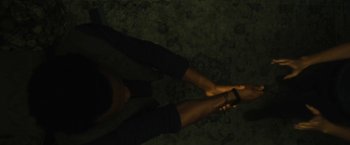 Movie still from “Daniel Isn't Real” (2019), directed by Adam Egypt Mortimer – A person's bare feet are shown in the dark; Close Up shot, Overhead angle