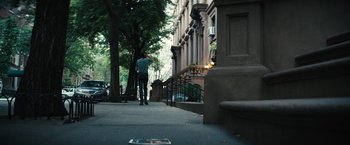 Movie still from “Daniel Isn't Real” (2019), directed by Adam Egypt Mortimer – A man walking down a sidewalk near a building; Wide shot, High angle