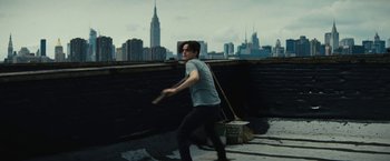 Movie still from “Daniel Isn't Real” (2019), directed by Adam Egypt Mortimer – A young man holding a broom and a paint bucket; Medium shot, High angle