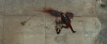 Movie still from “Daniel Isn't Real” (2019), directed by Adam Egypt Mortimer – Two people are laying on the ground near a puddle of blood; Wide shot, Overhead angle