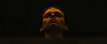 Movie still from “Daniel Isn't Real” (2019), directed by Adam Egypt Mortimer – A man with his eyes closed in a dark room; Close Up shot, Low angle