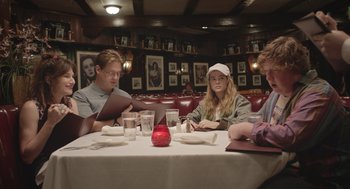 Movie still from “Flower” (2017), directed by Max Winkler – A group of people sitting at a table in a restaurant; Medium shot, Over the shoulder angle